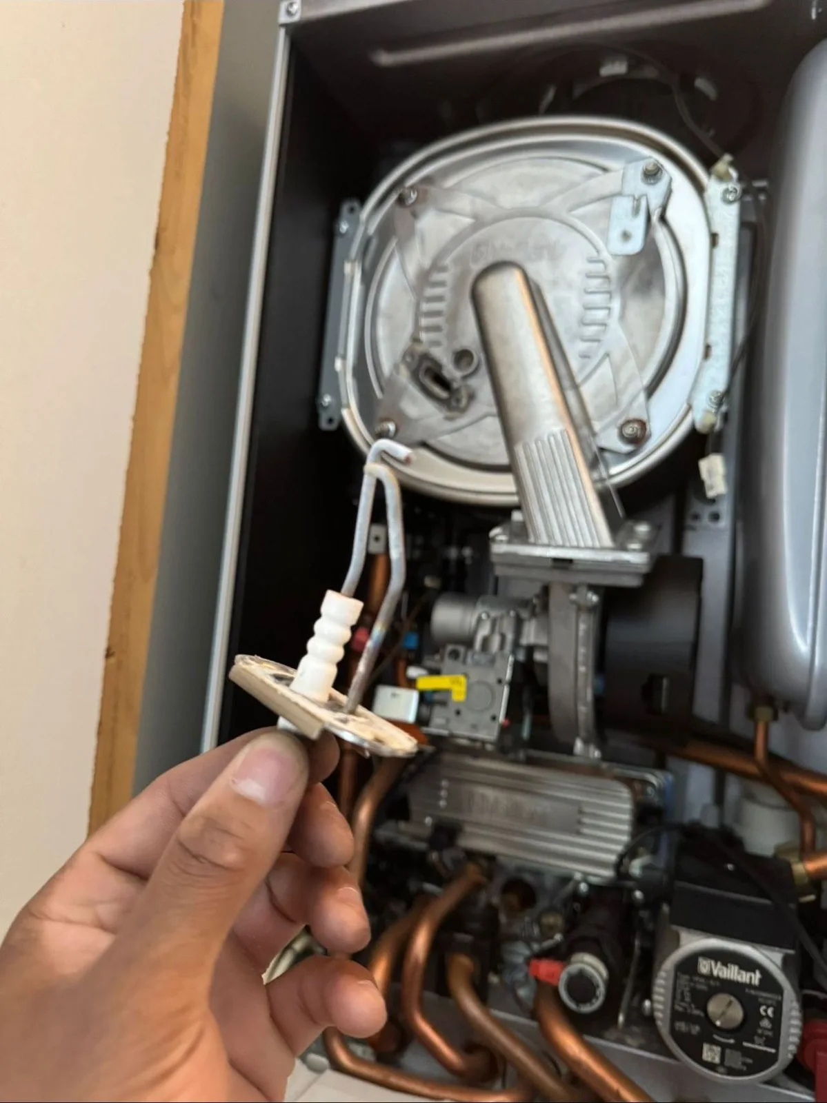Engineer stripping down a boiler burner and heat exchanger for cleaning