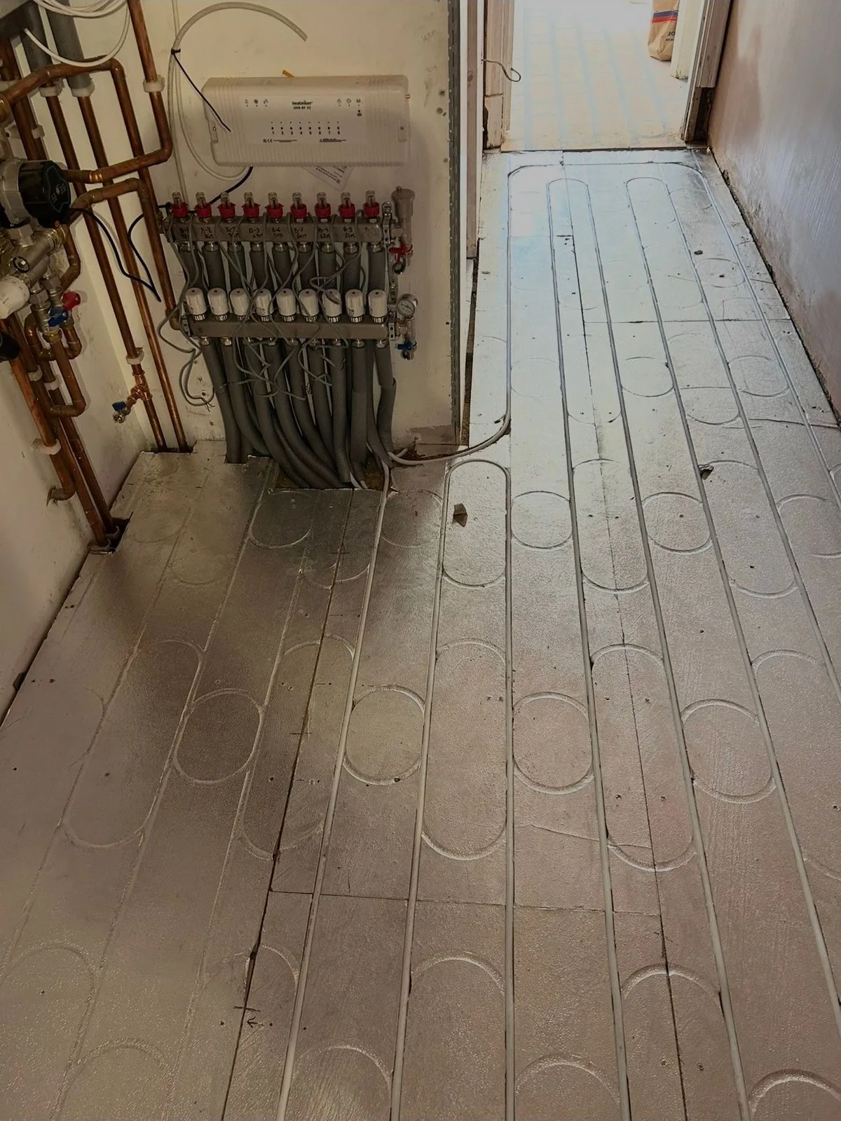 Underfloor heating pipework routed across a prepared floor